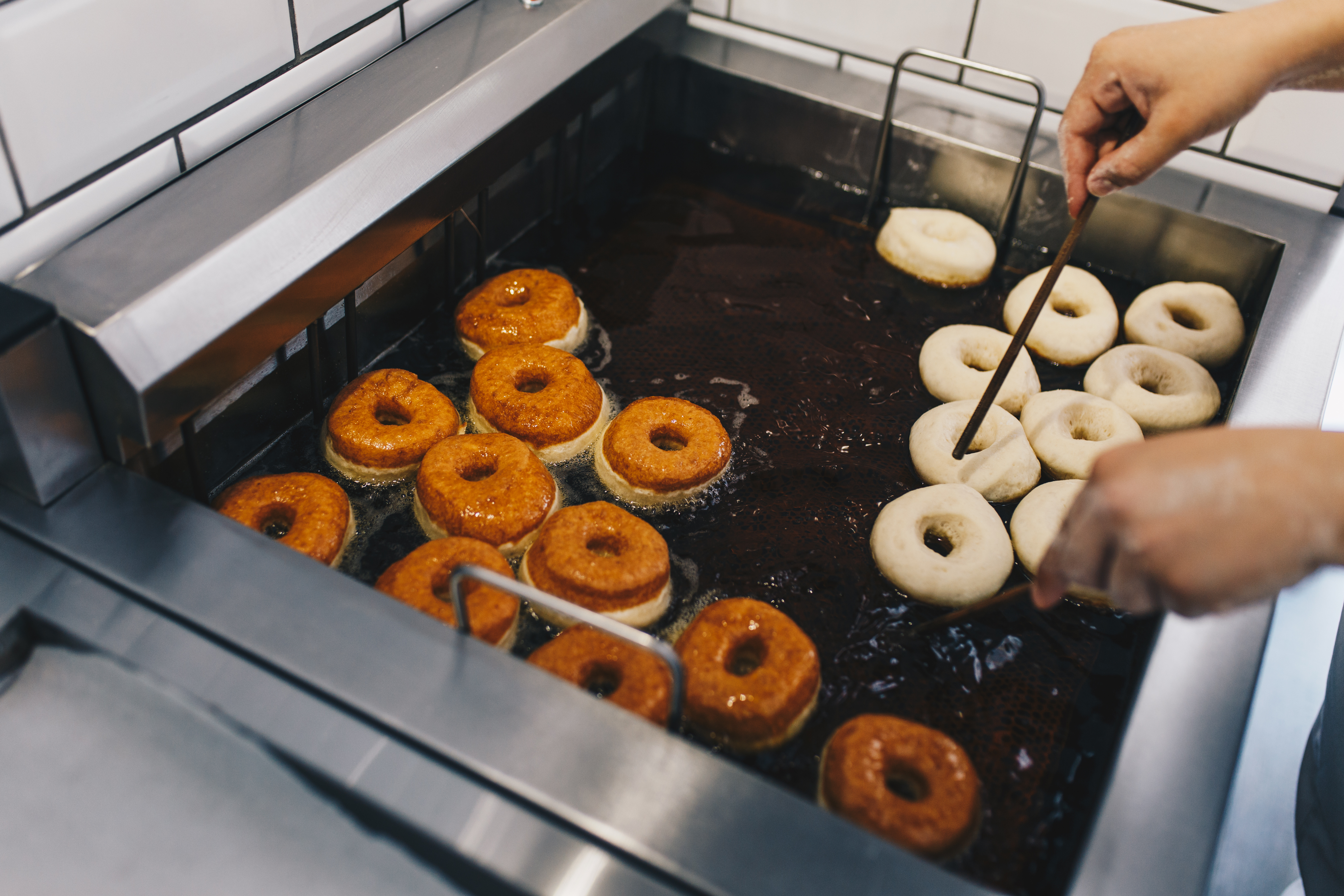 Donuts being hand glazed in the pastry kitchen
