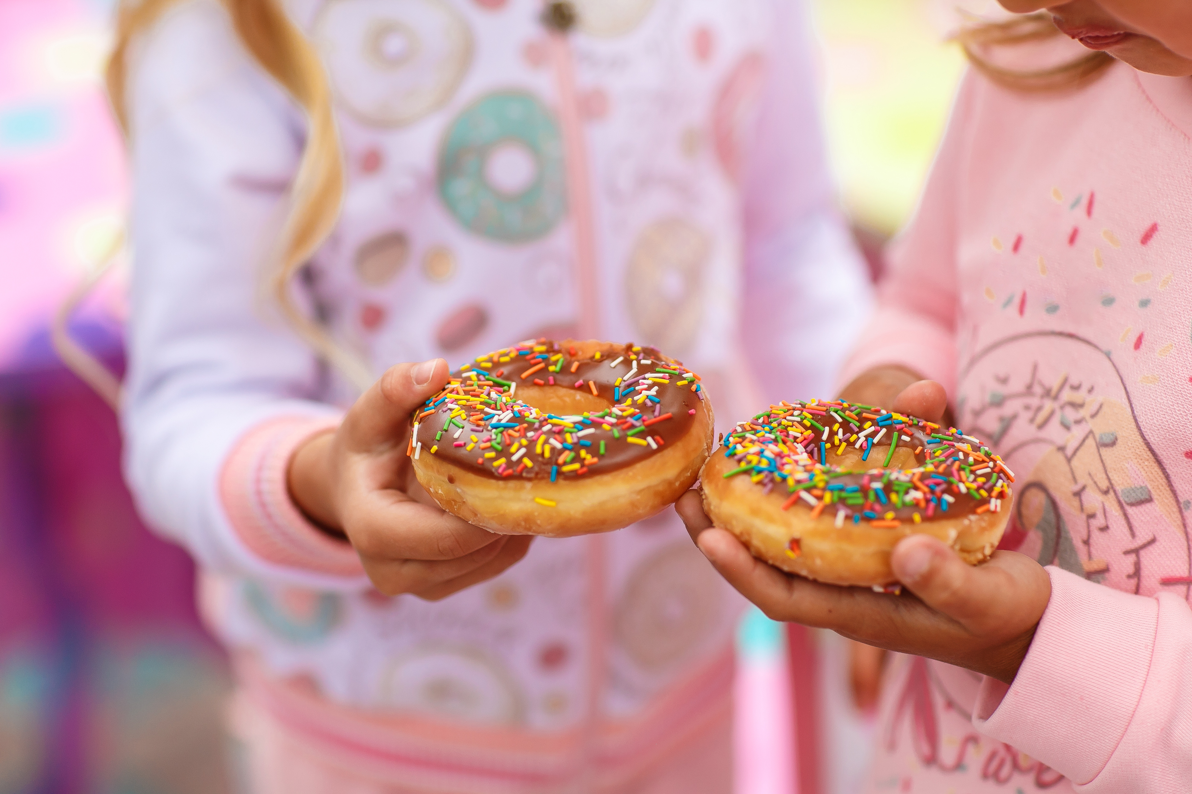 A guest holding a freshly glazed donut